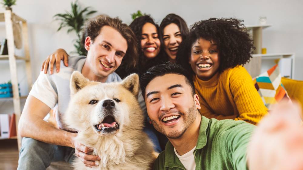 A group of diverse friends taking selfie photos at home.