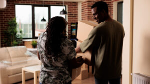 African American people carrying furniture to new apartment